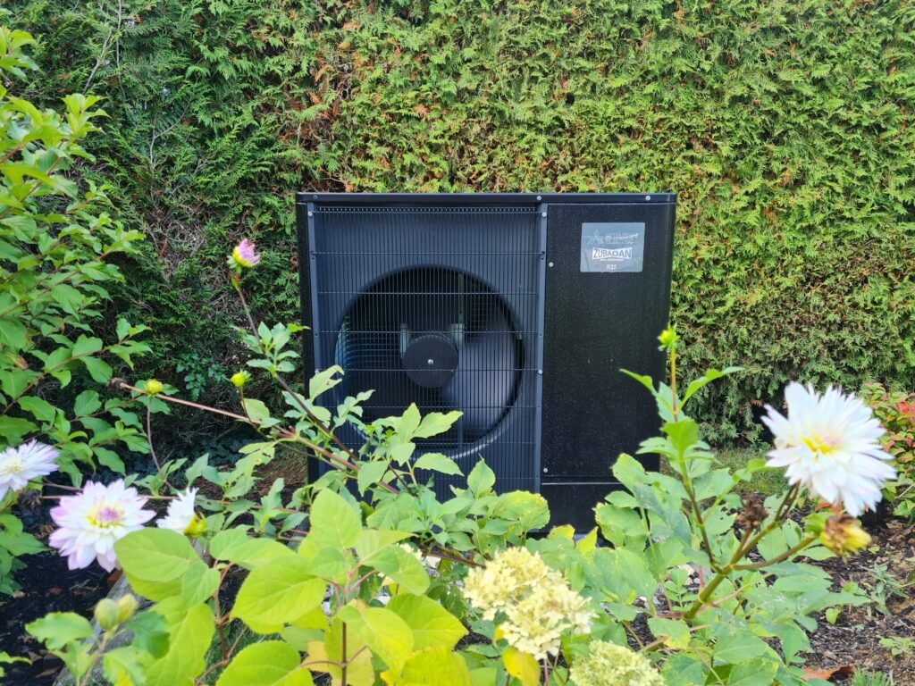 Image d'un jardin avec une pompe à chaleur Mitsubishi noire installé par AFM