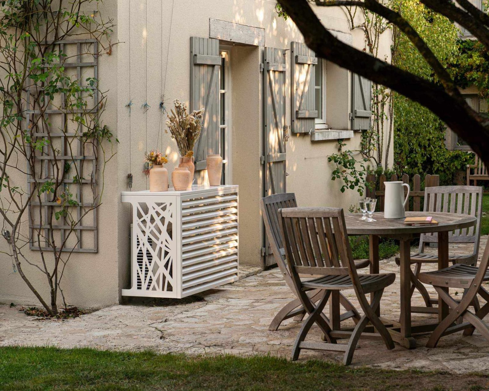 Image d'un salon extérieur en Lausanne avec une climatisation recouverte d'un cache servant de décoration