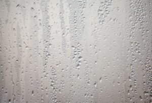Detailed view of water droplets creating patterns on glass surface.